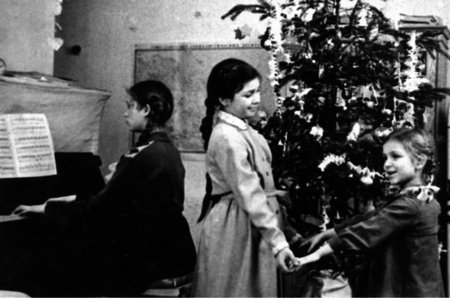 Праздник Нового года. Галя и Марина танцуют у елки  под аккомпанемент Тани. 1962